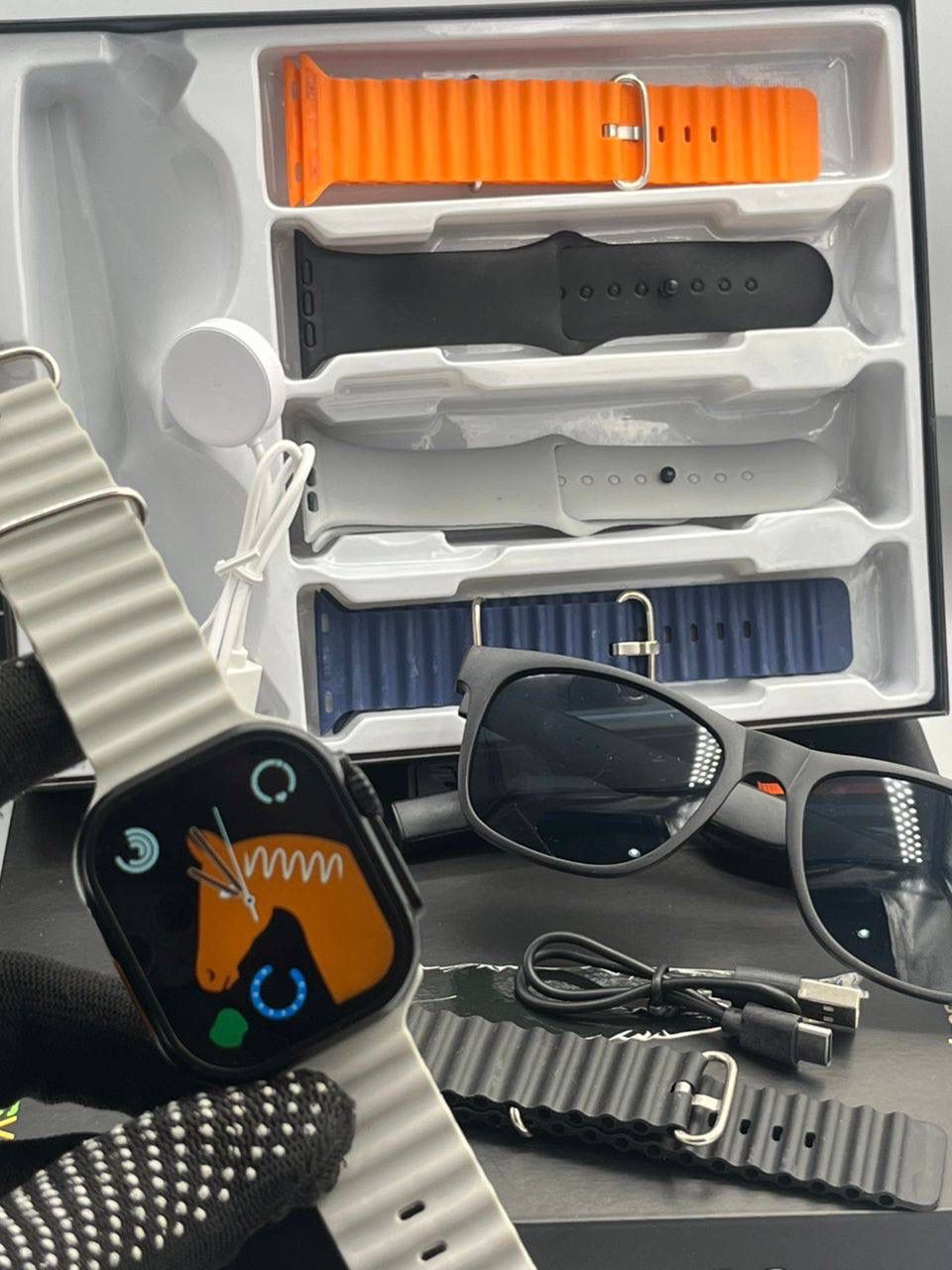 Smartwatch with smart sunglasses, interchangeable straps, USB‑C charging, built‑in speakers, and health‑tracking display.